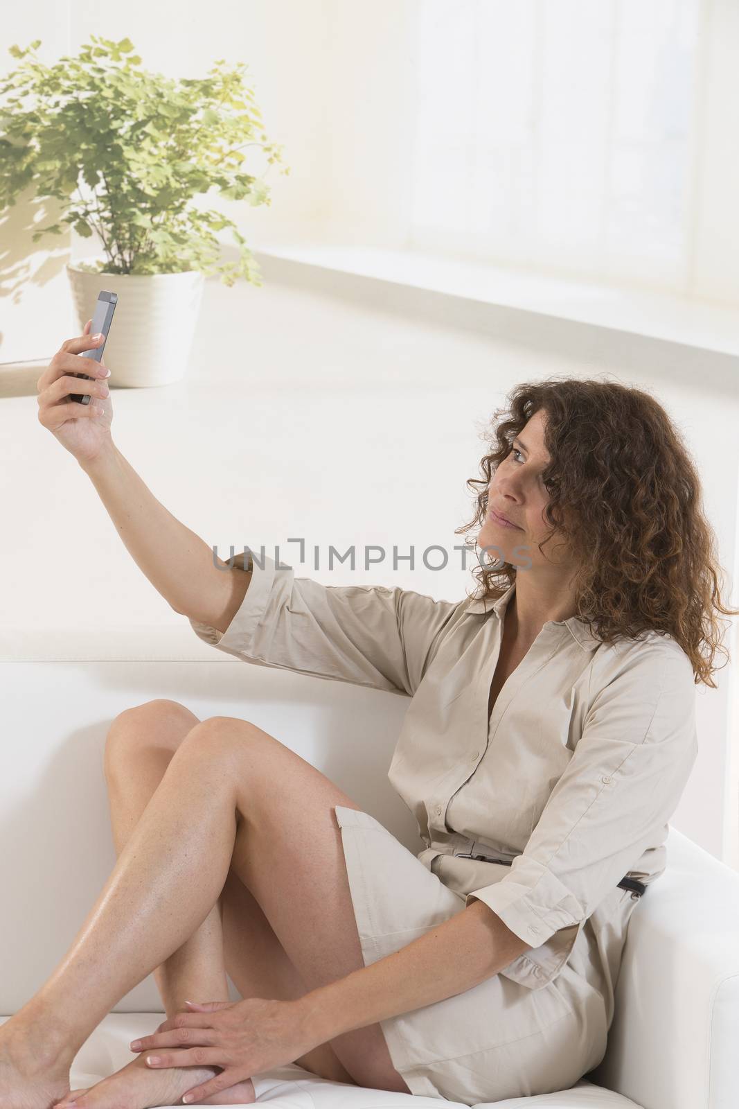 Beautiful curly hair woman in bed taking selfie