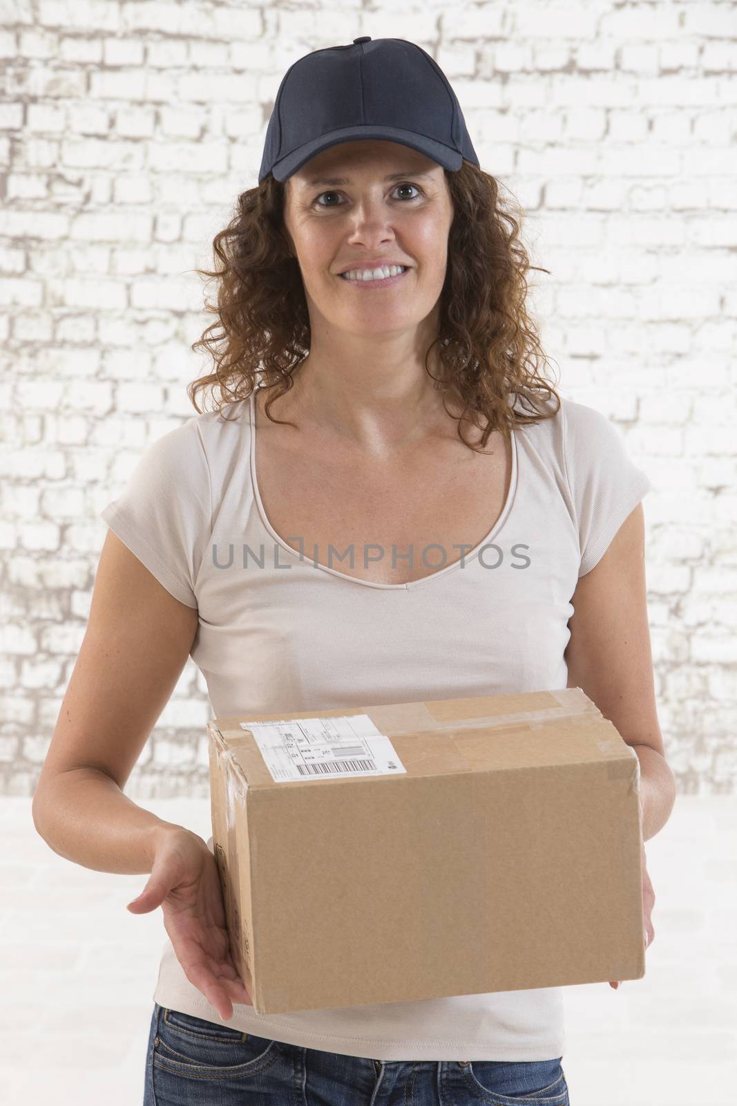 Delivery person holding packages wearing blue cap by JPC-PROD