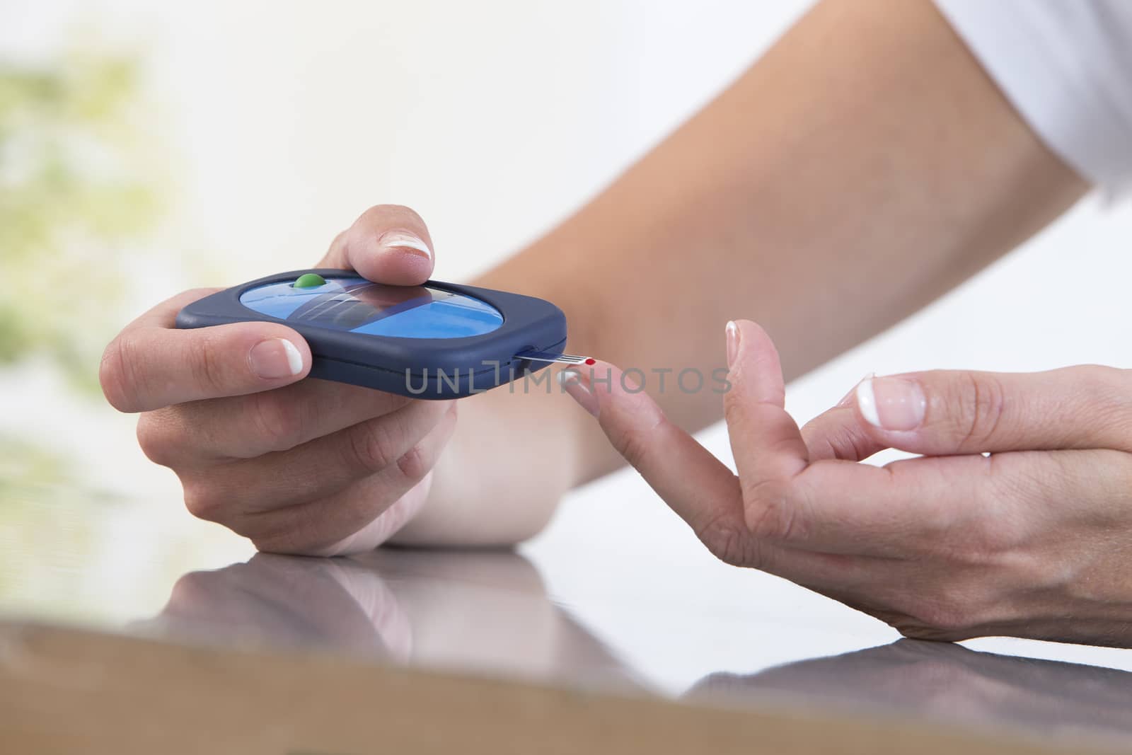 Woman doing blood sugar test by JPC-PROD