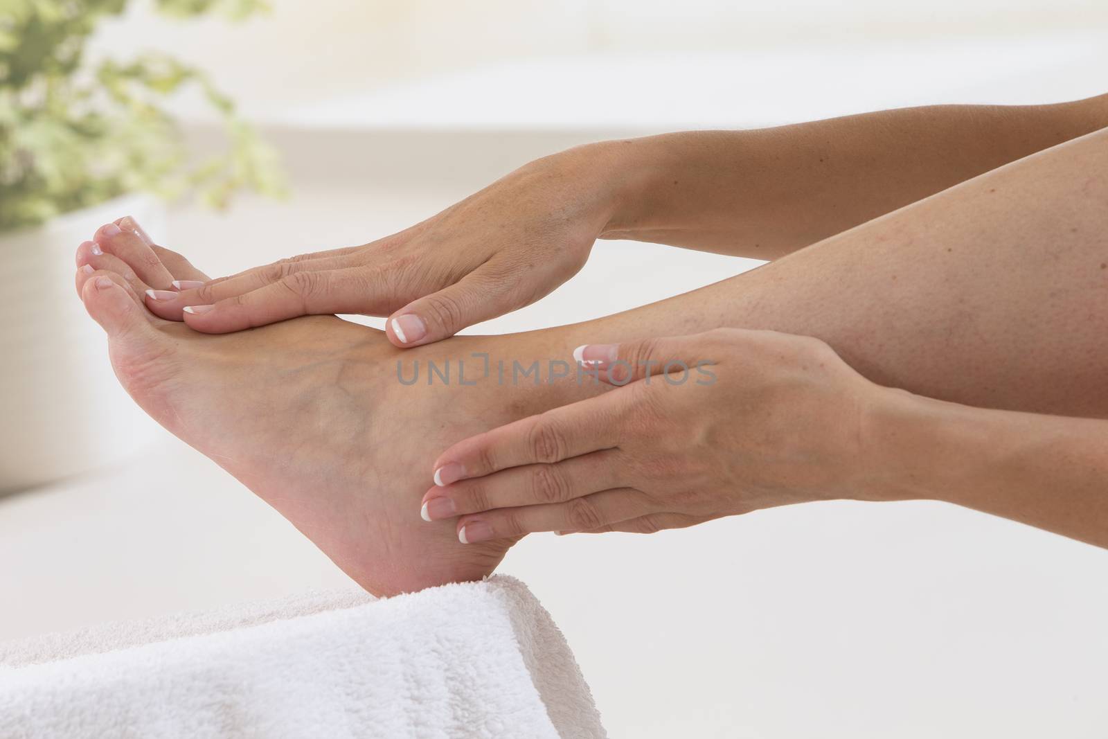 Woman massaging her foot and ankle  with manucured nail by JPC-PROD