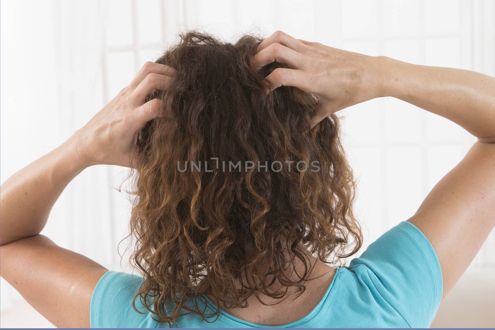 Woman suffering from an headache itching her head