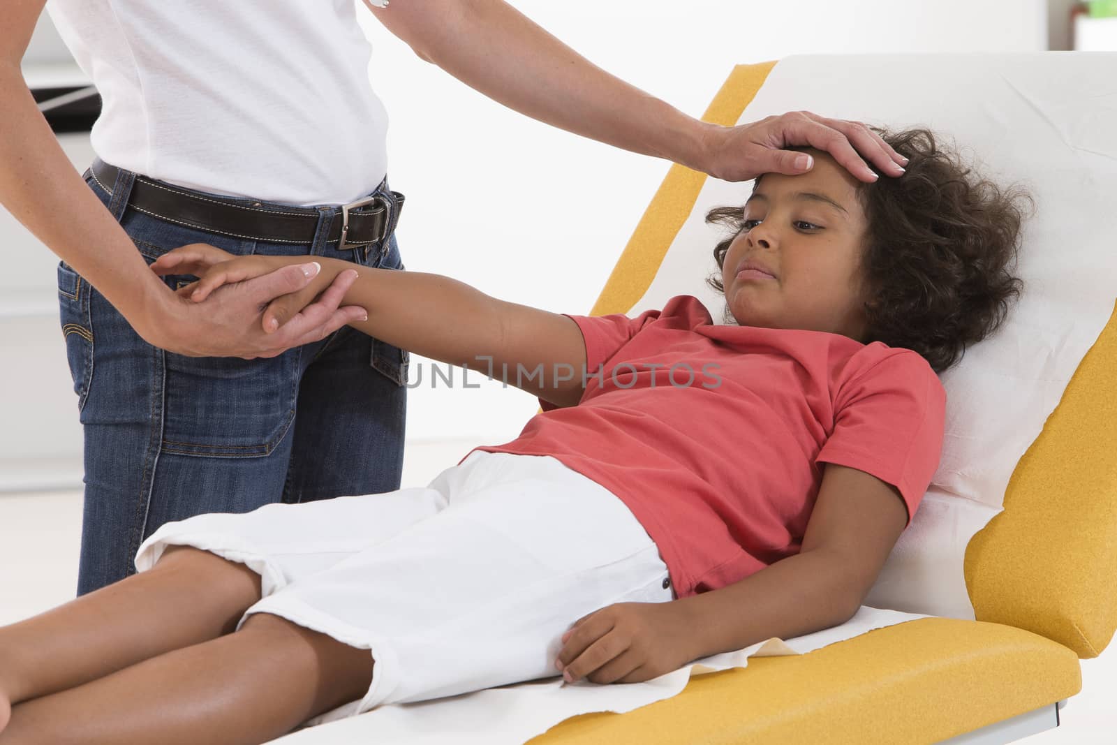 doctor checks the temperature of a boy touching his forehead by JPC-PROD