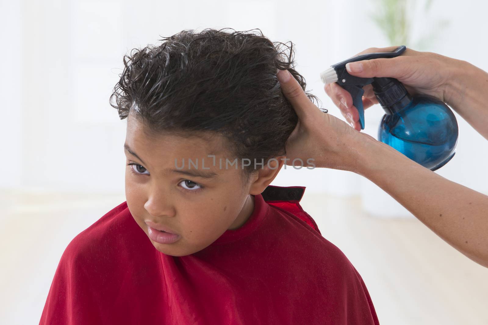 A lovely child in the hairdresser salon cutting his hair