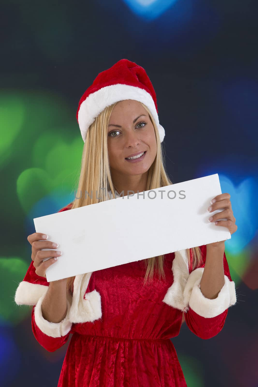 beautiful girl in red Santa Claus costume holding a blank board