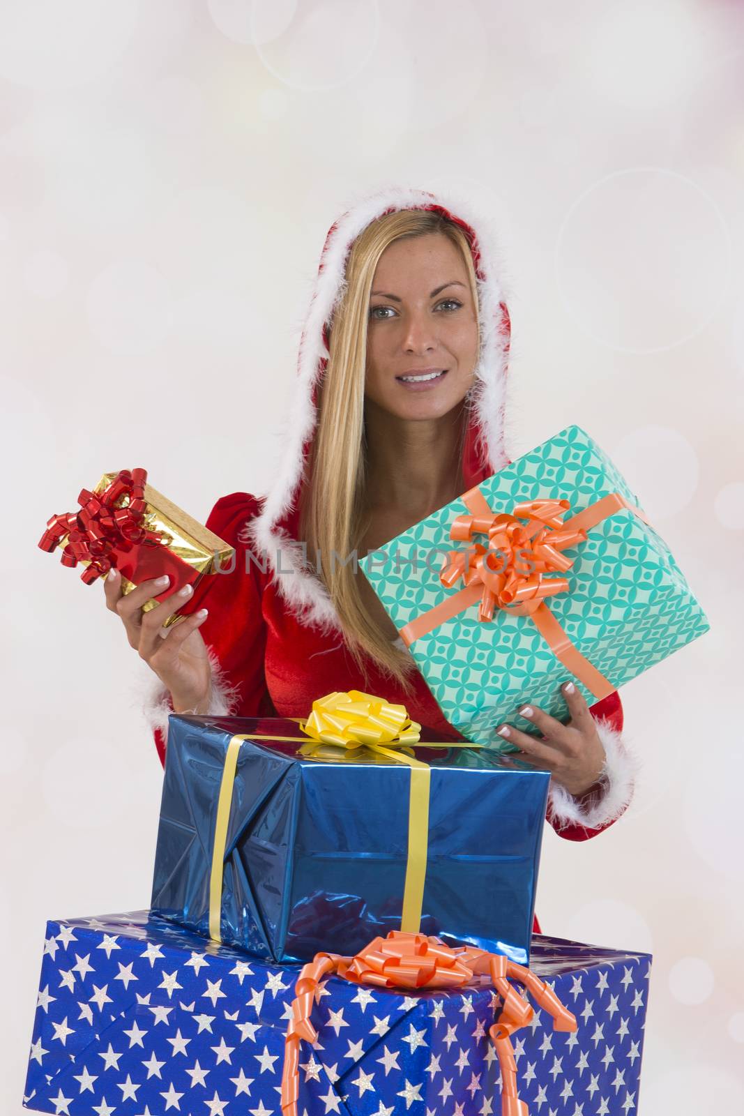 Beautiful young woman in Santa Claus clothes over with gifts