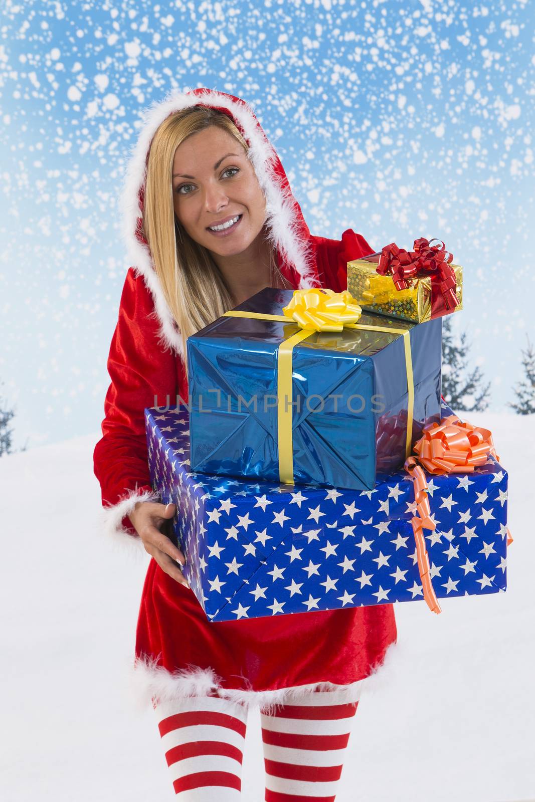 Beautiful young woman in Santa Claus clothes  with gifts on blue sky background