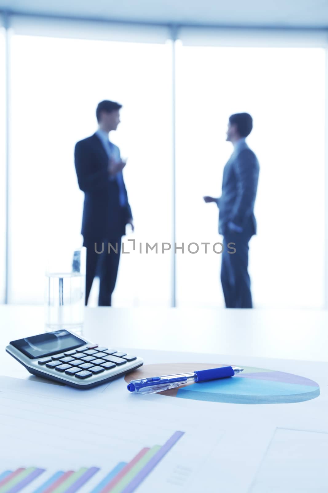 Financial reports, calculator and laptop on table in office