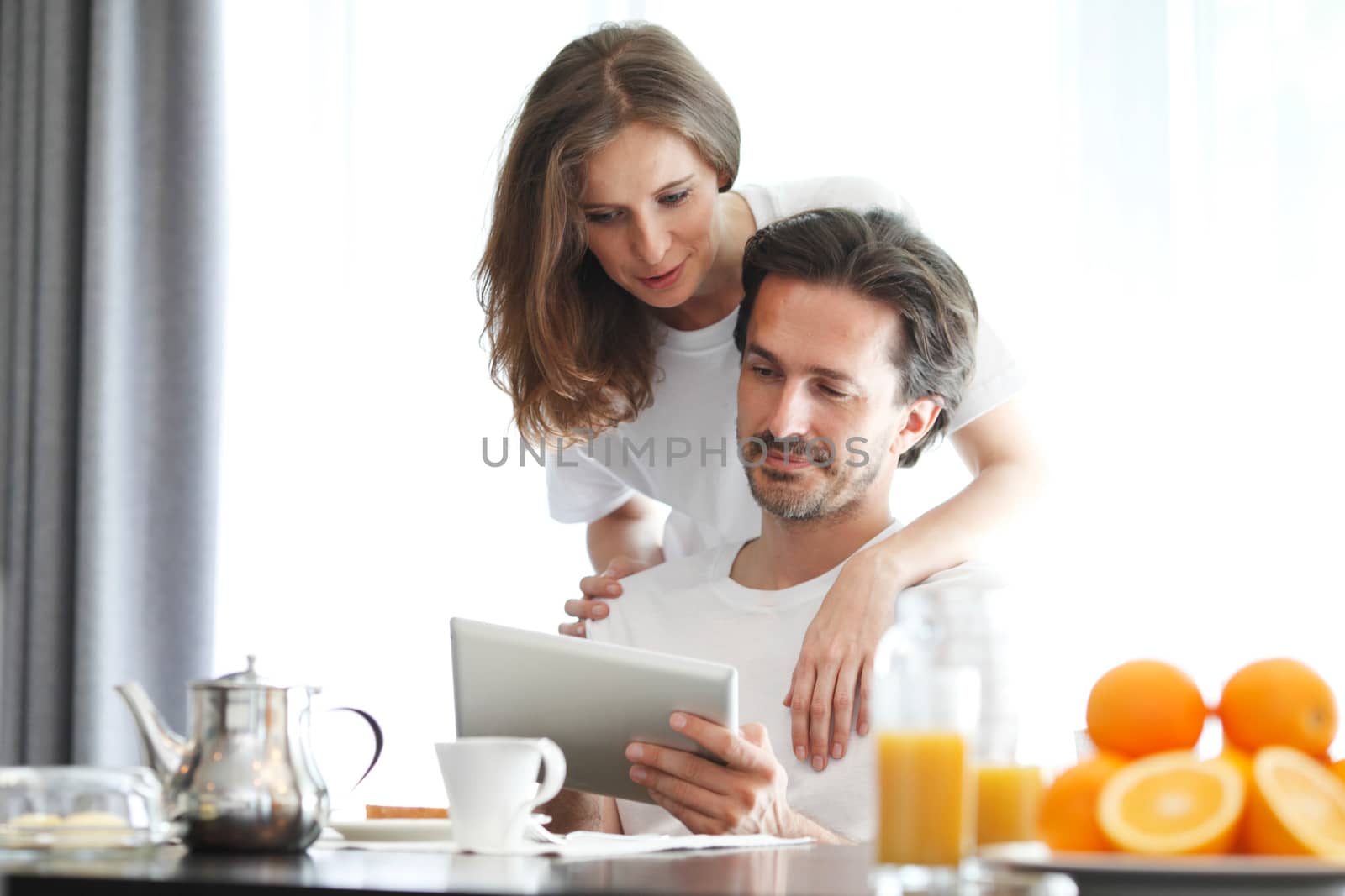 couple at breakfast with tablet by ALotOfPeople