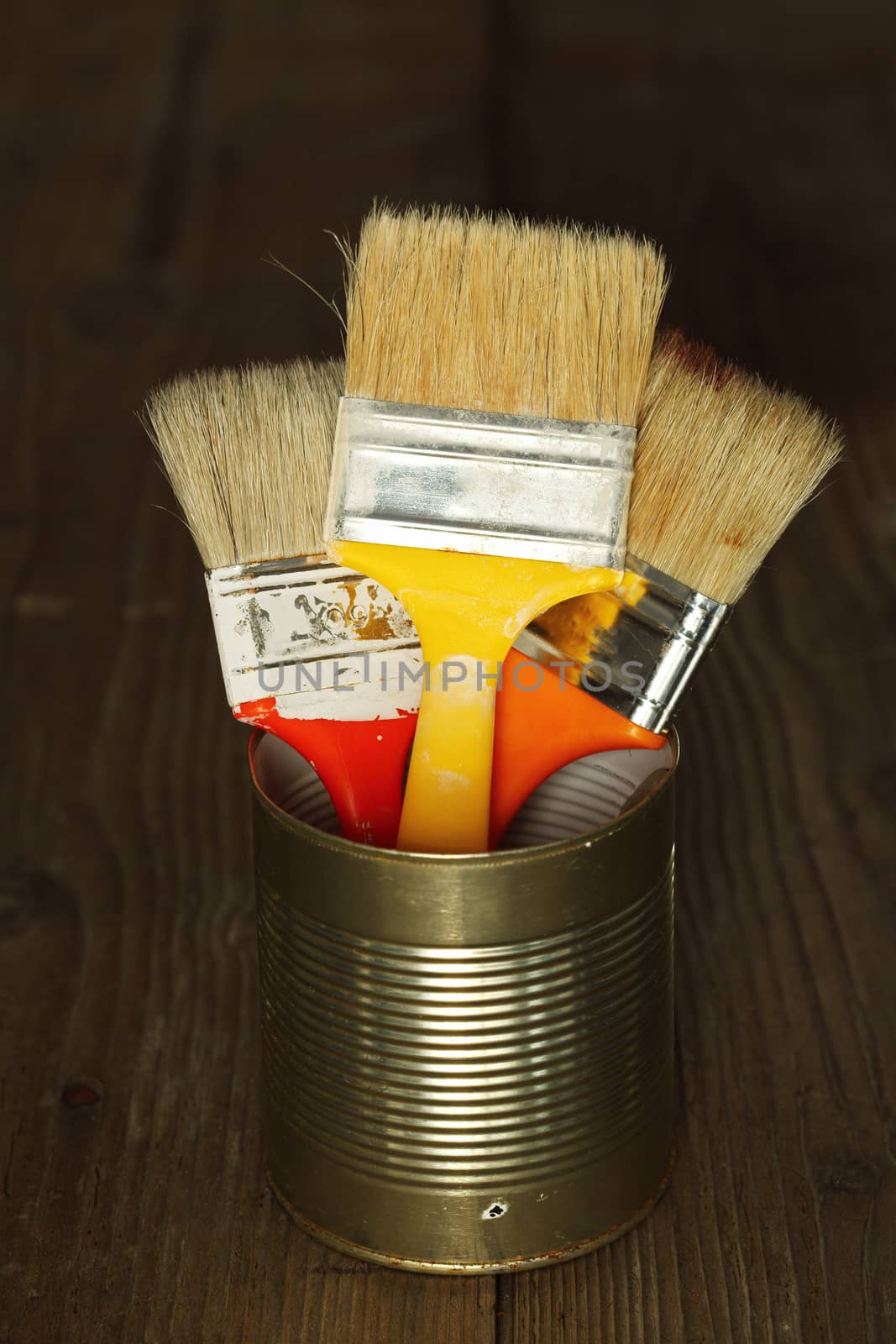 Three clean paint brushes in tin can