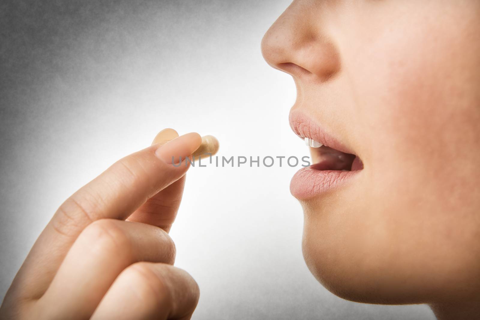 Closeup of woman taking pill