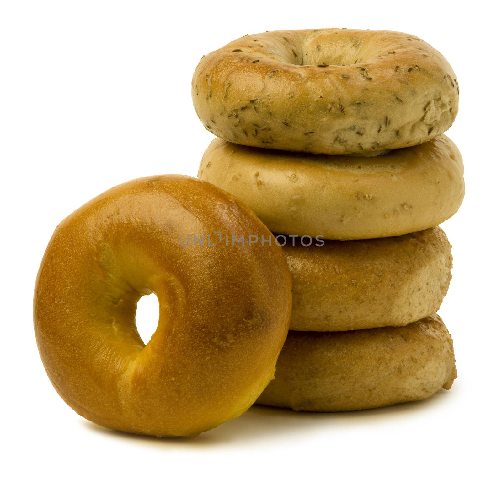 Stack of four bagels with one leaning on the side against white background.