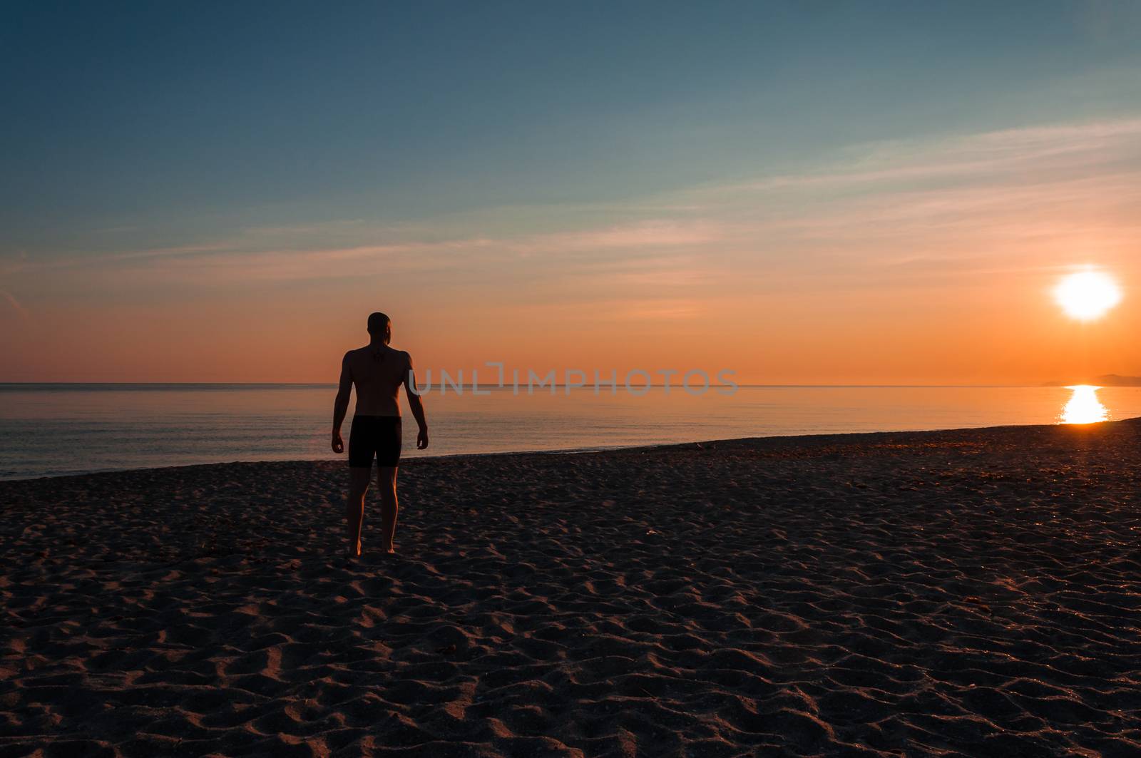 silhouette of man staring at the sea at sunset, fitness