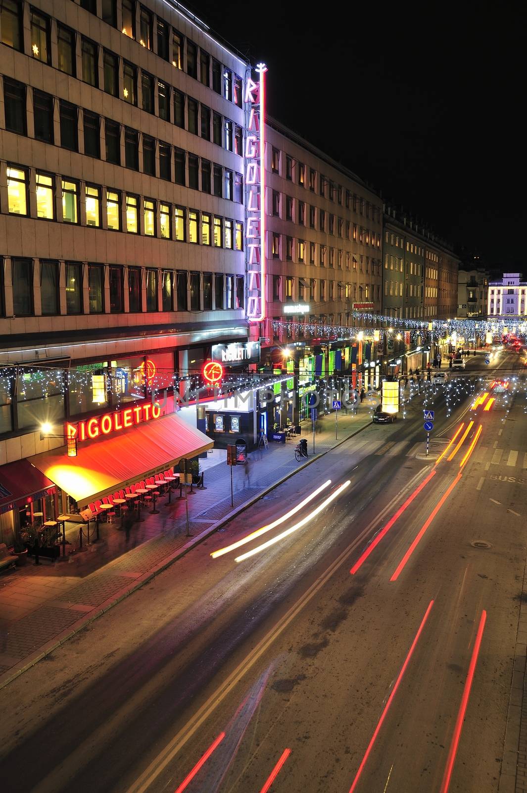 Stockholm, Sweden - December 7, 2013: Night traffic on Kungsgatan in central Stockholm. Cars, pedestrians, taxis in traffic close to the crossing with Sveavagen.