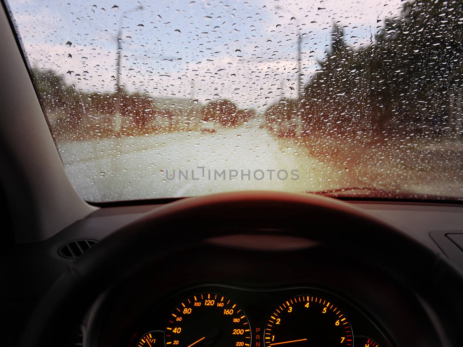 dashboard and rain droplets on car windshield