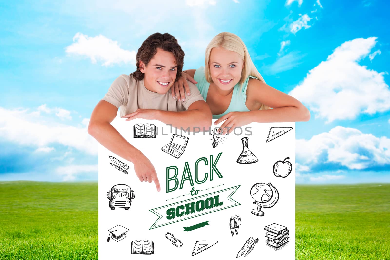 Handsome Man pointing on a whiteboard with woman against blue sky over green field