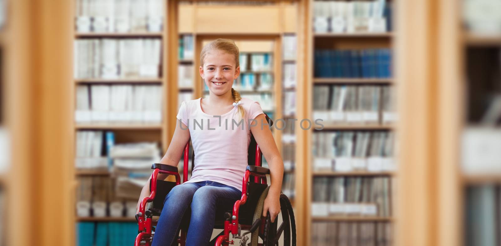 Girl sitting in wheelchair in school corridor against library