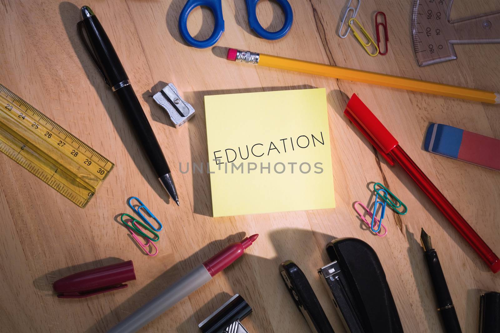 Education against students table with school supplies by Wavebreakmedia