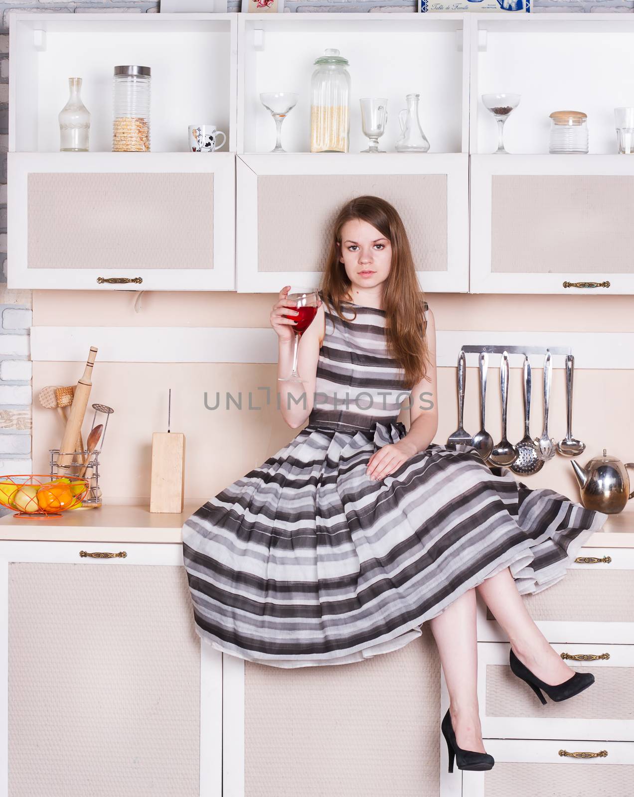 Girl in a lush gray dress sitting in the kitchen