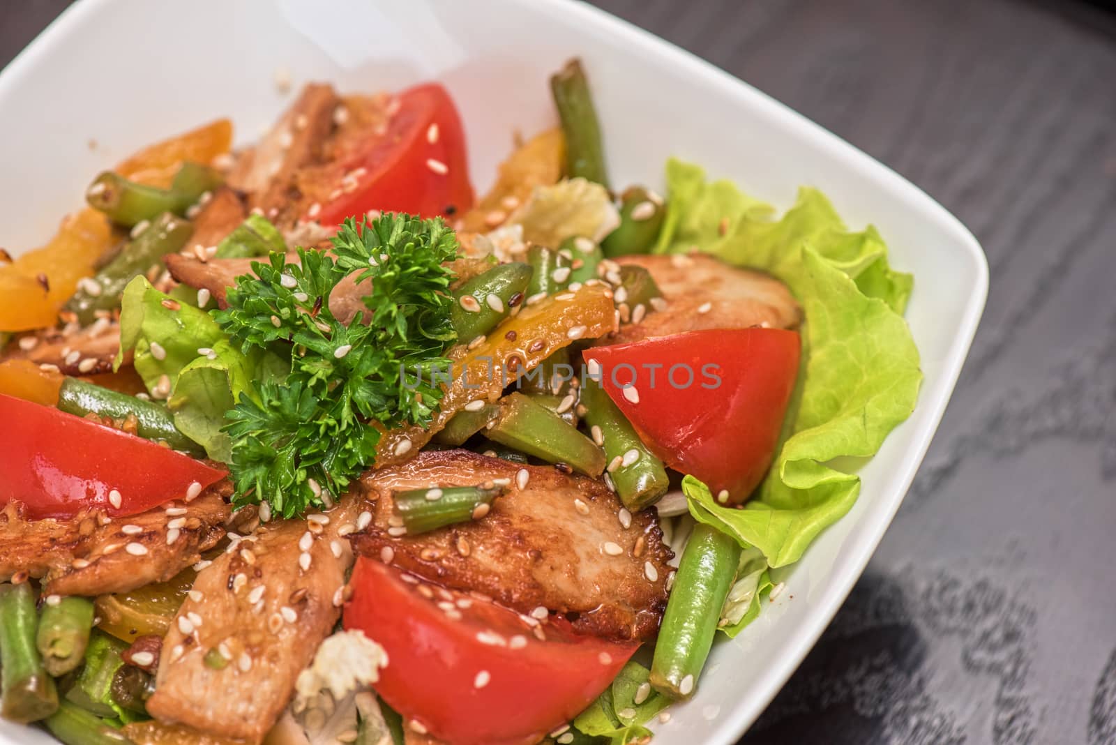 Warm salad with chicken, vegetable and sesame seeds