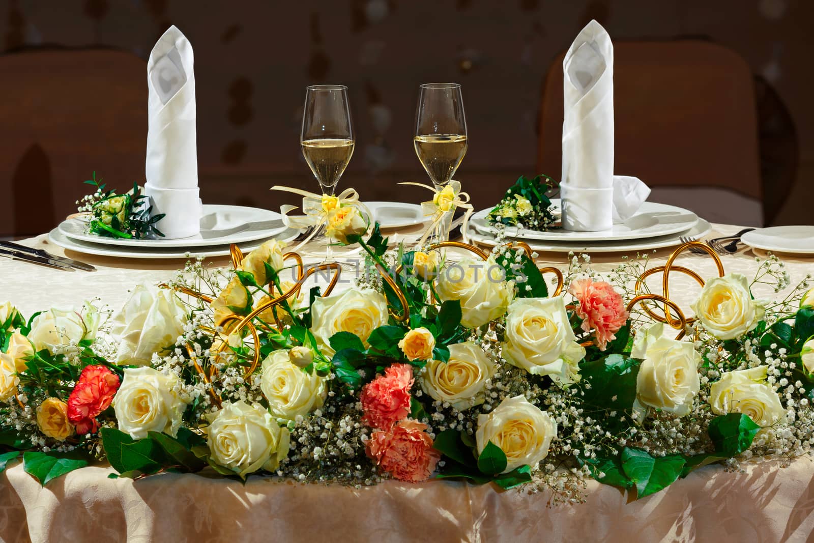 Decorated wedding table for newlyweds with two glasses of champagne.