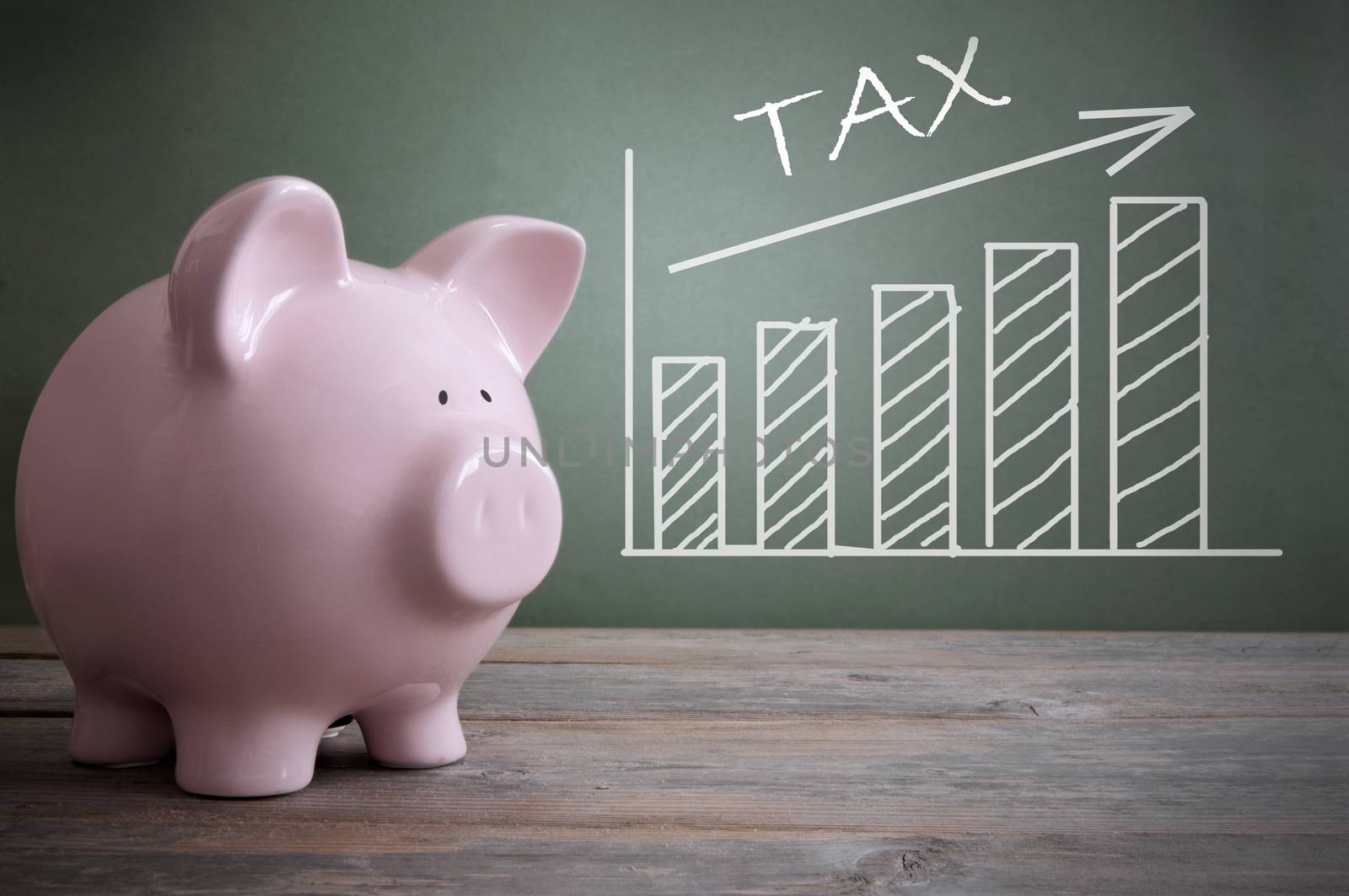 Chalk board tax chart with arrow pointing upwards by a piggy bank