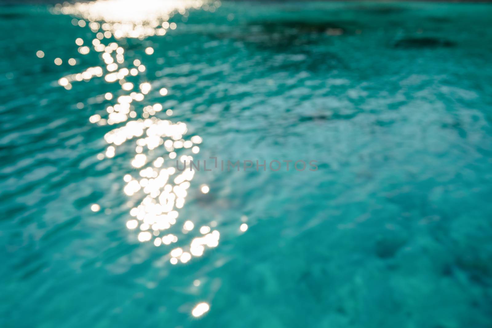 Blur green blue sea surface with reflecting sunlight evening in summer for background