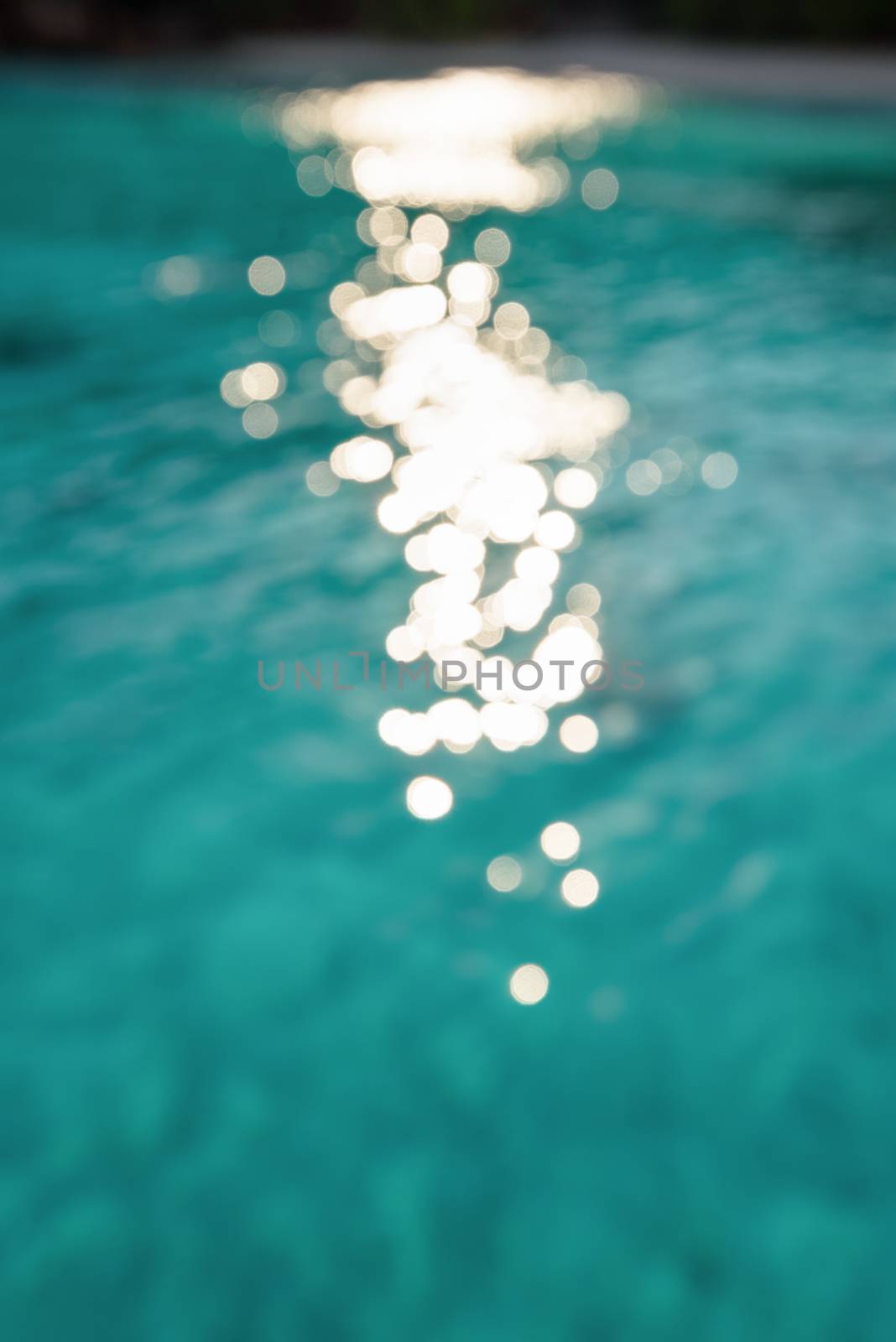 Blur green blue sea surface with reflecting sunlight evening in summer for background