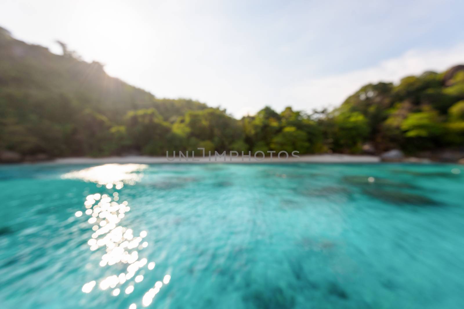 Blur beach and green blue sea surface with reflecting sunlight evening in summer for background