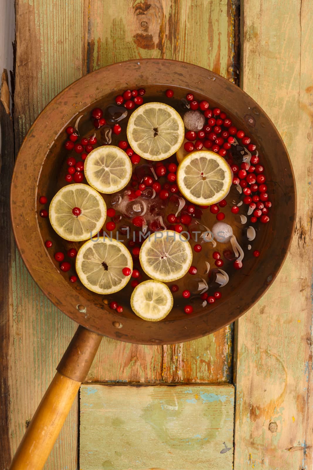 Cranberry lemon punch in a brass bowl on wooden table