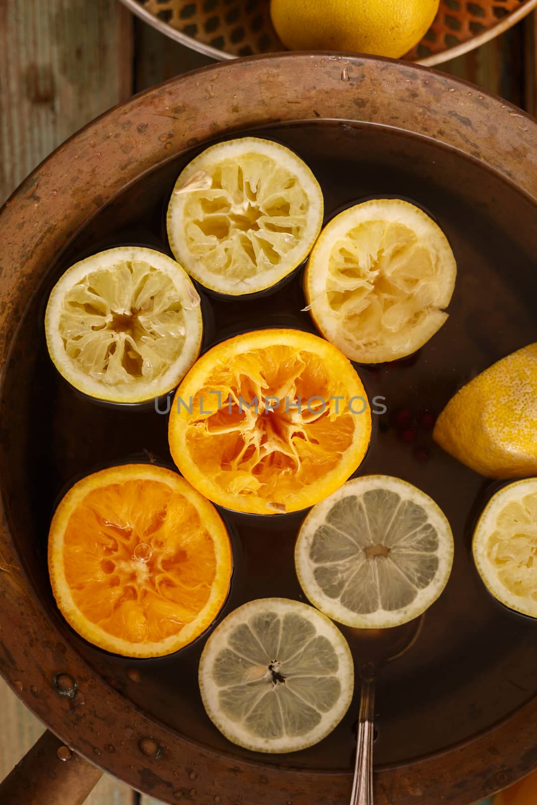 Top view of brass pot with lemonade,detox water or punch with lemons and oranges