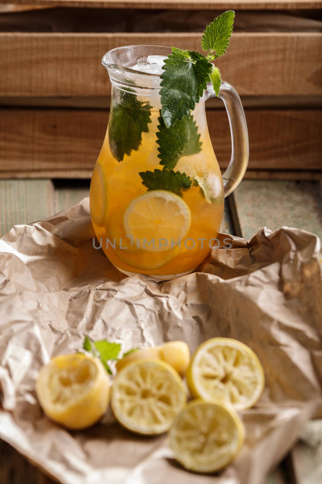 Jug of Iced lemonade with lemon balm. Rustic styled, selective focus