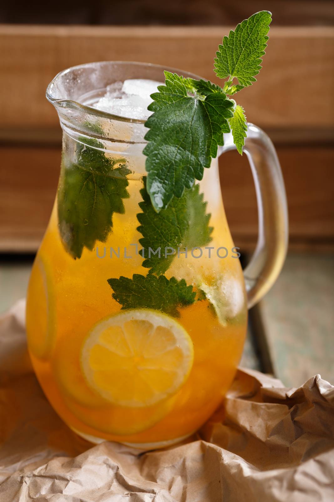 Jug of Iced lemonade with lemon balm. Rustic styled, selective focus
