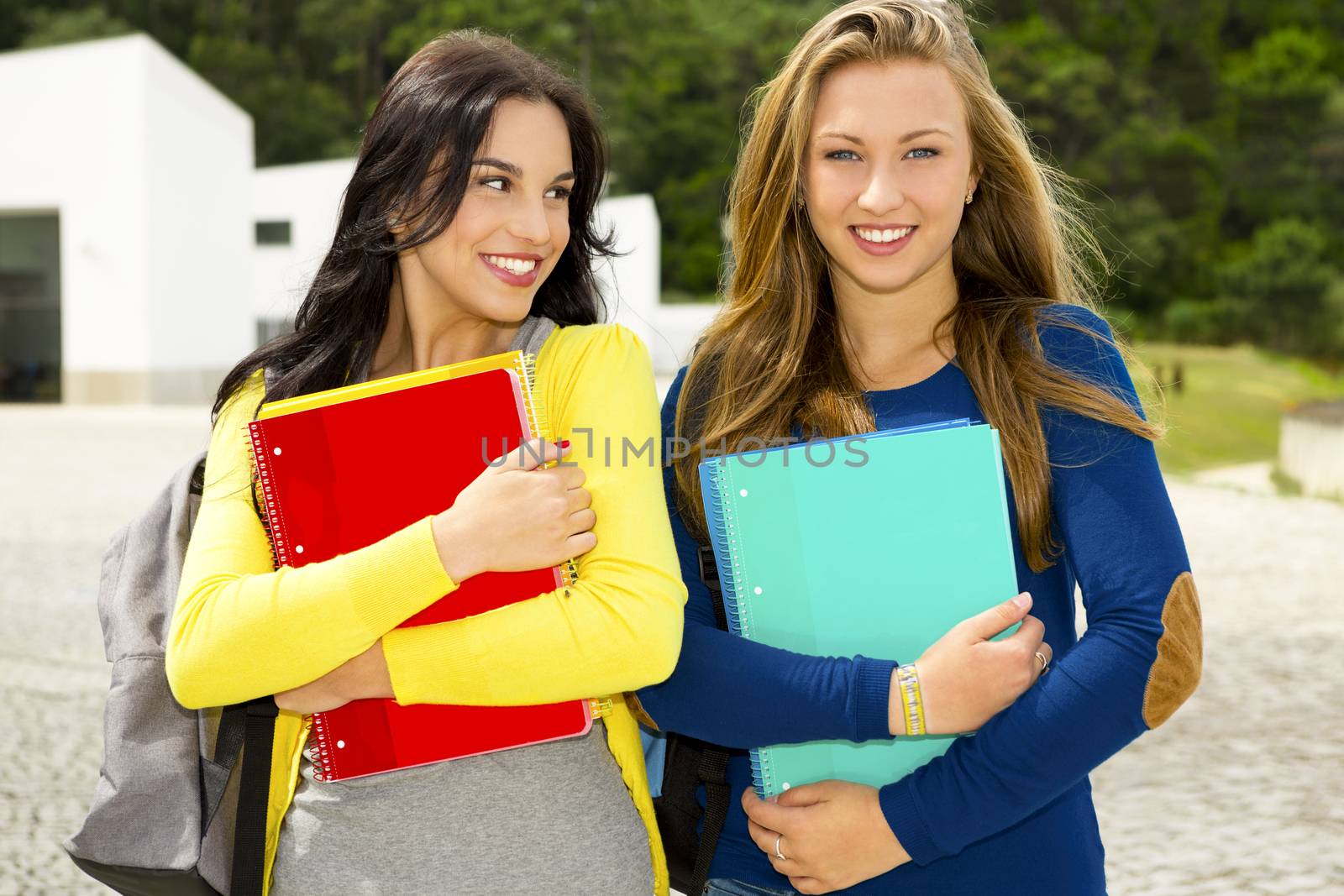 Two beautiful teenage students walking and smiling 