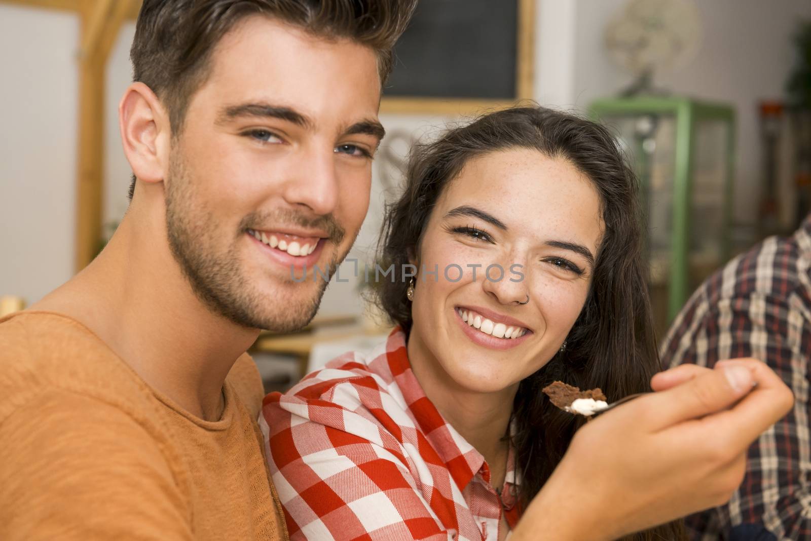 Happy couple at the restaurant and giving food in mouth