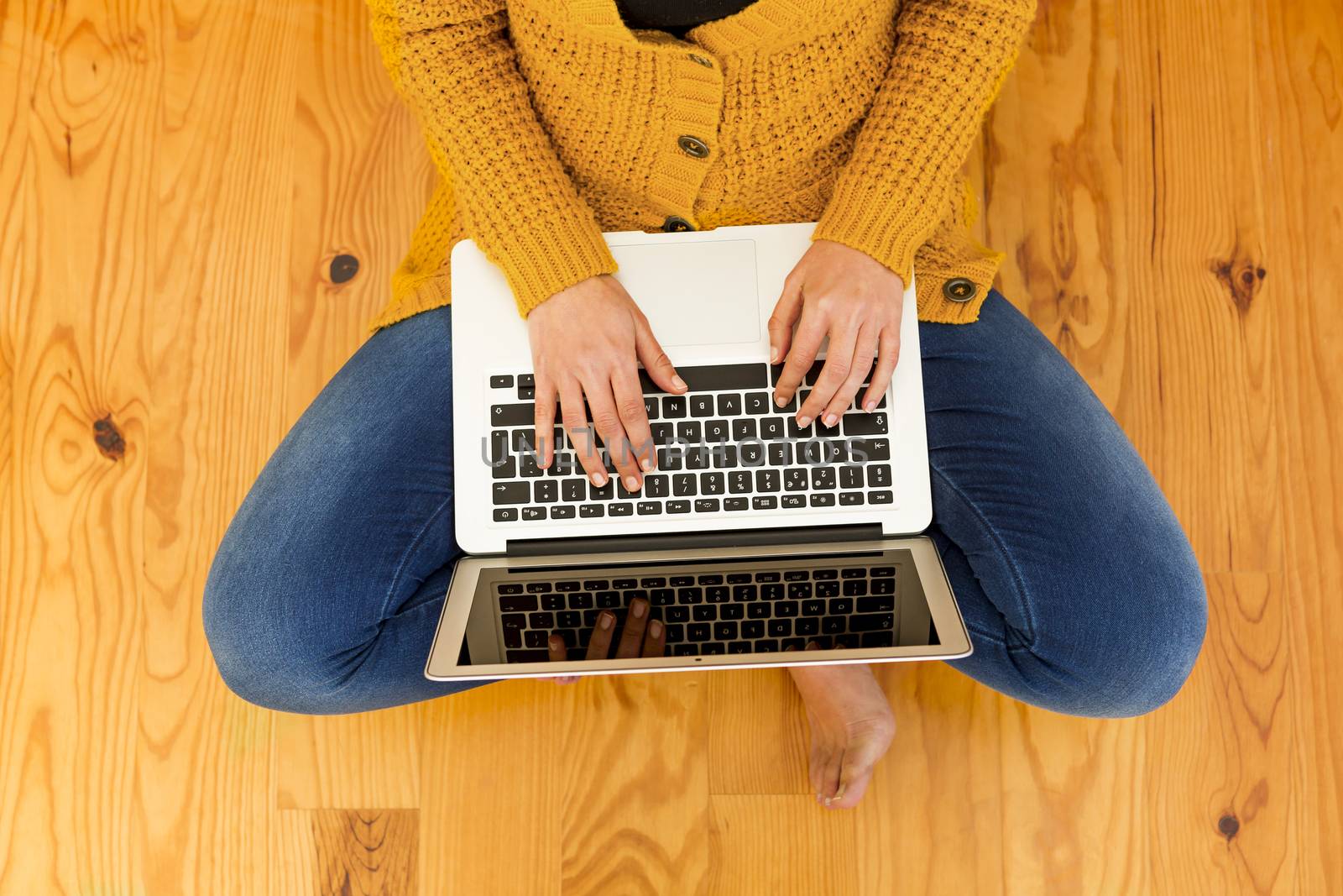 Beautiful woman sitting on the floor working on the laptop