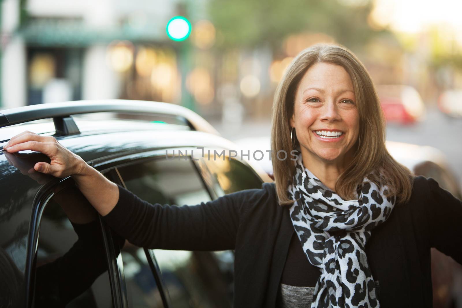 Beautiful adult business woman outdoors standing next to car