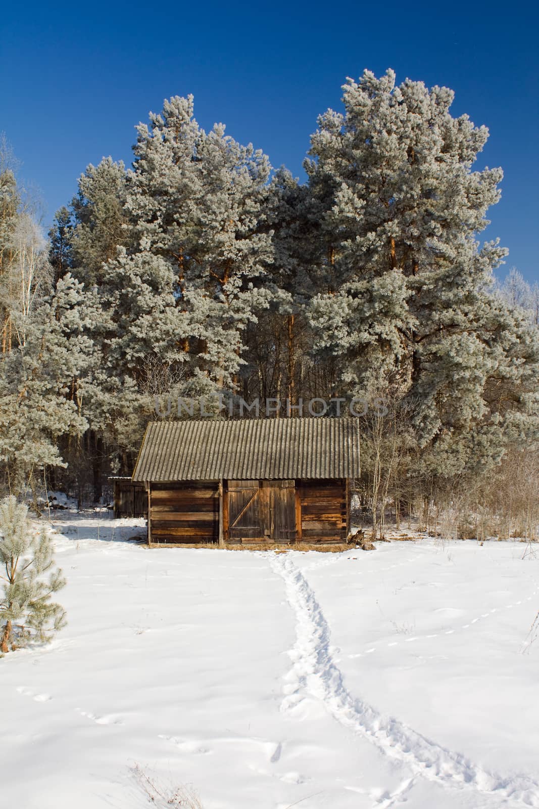 a wooden building covered with snow in the winter time