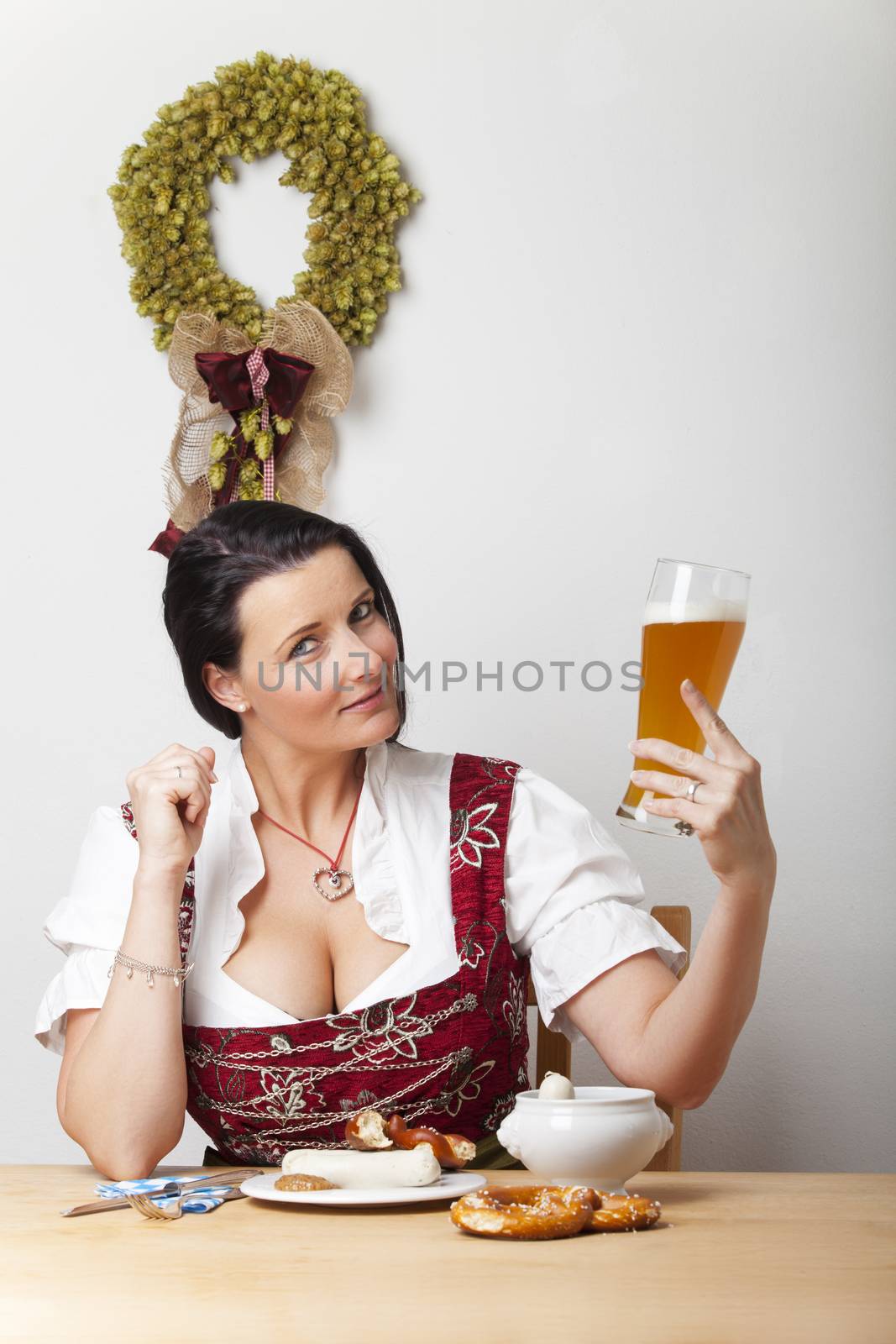 bavarian woman in a dirndl with sausages by bernjuer