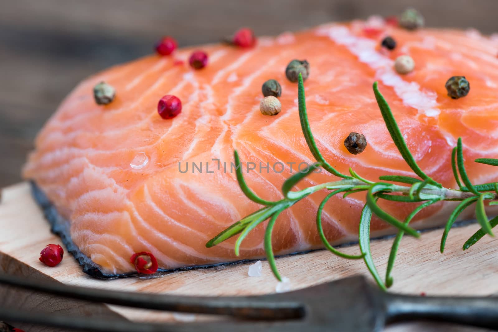 Raw Salmon Fish Fillet with Fresh Herbs on Cutting Board ready to Cook