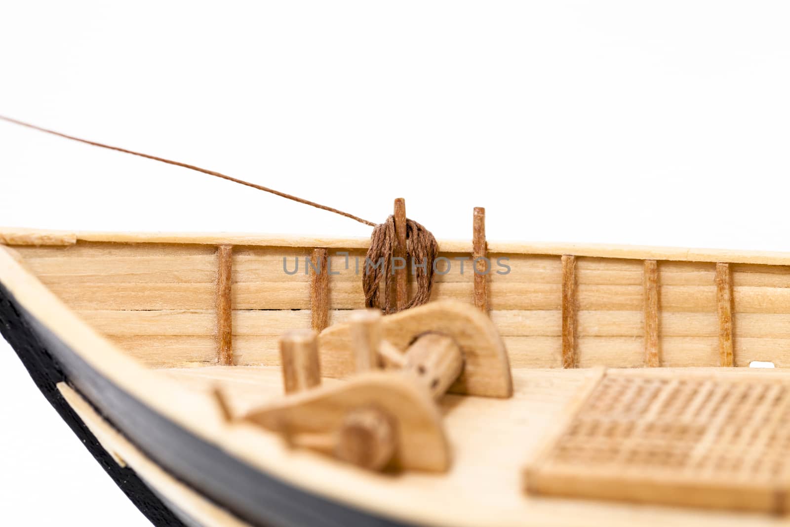   the wooden model of the ship photographed by a close up. focus on ropes