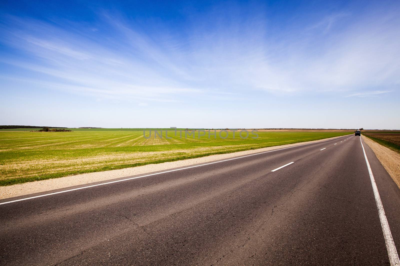   the asphalted road along an agricultural field is expensive. spring