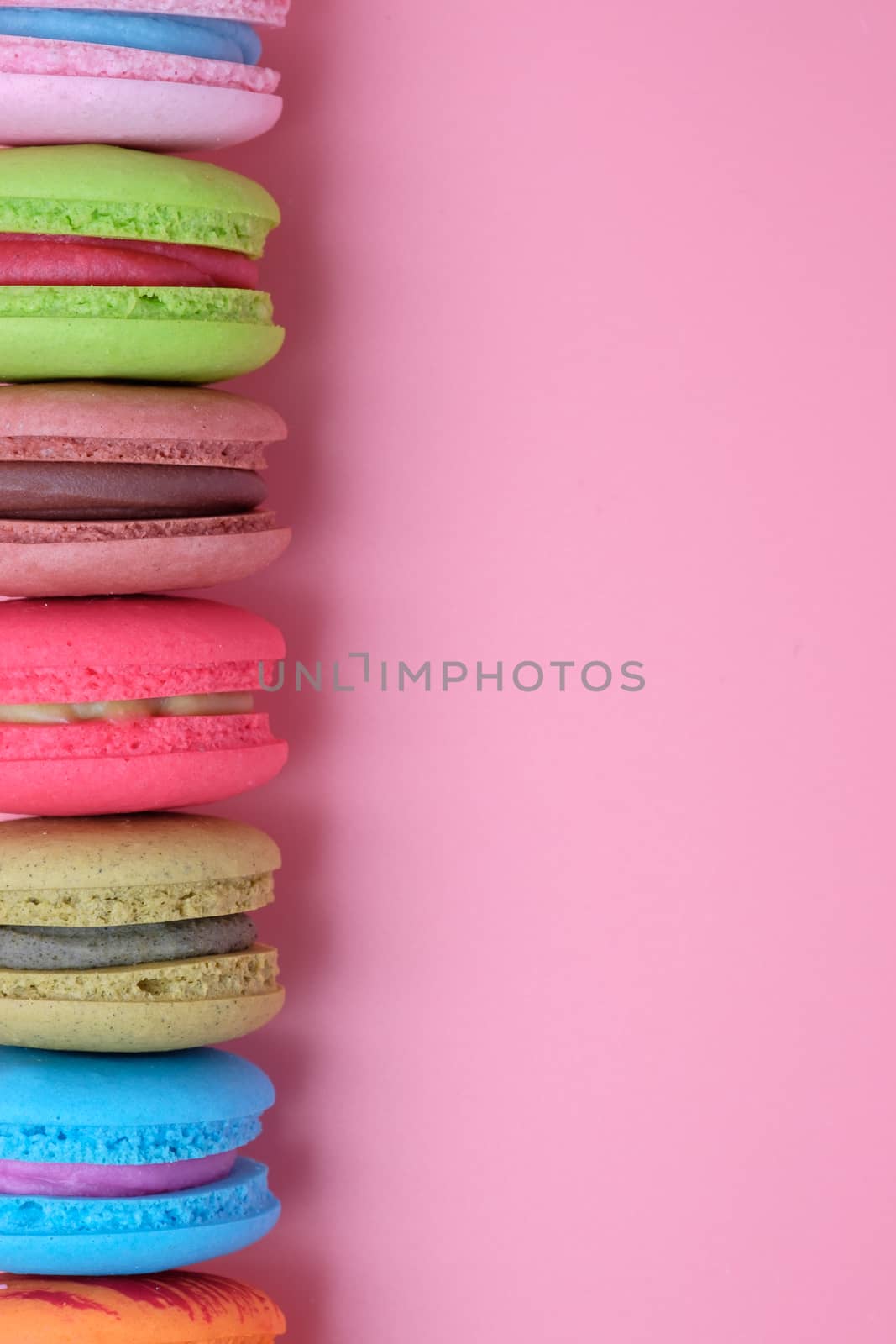 Sweet and colourful french macaroons on pastel pink background