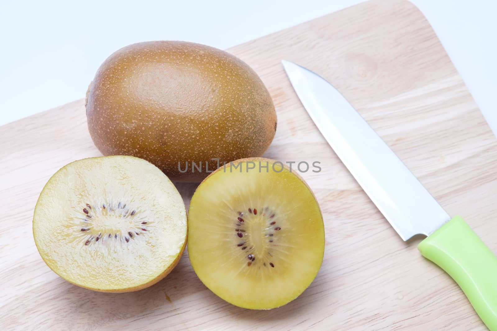 Kiwi on wooden chopping block.