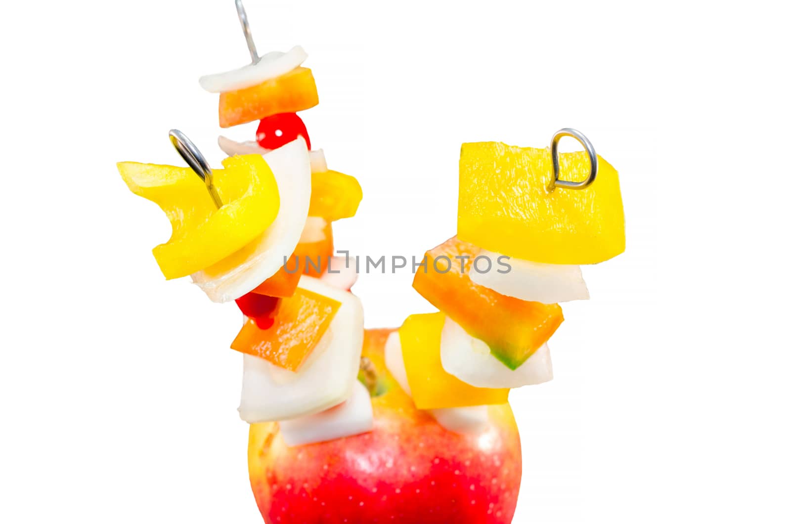 Vitamin-rich fruit skewers in an apple against white background.