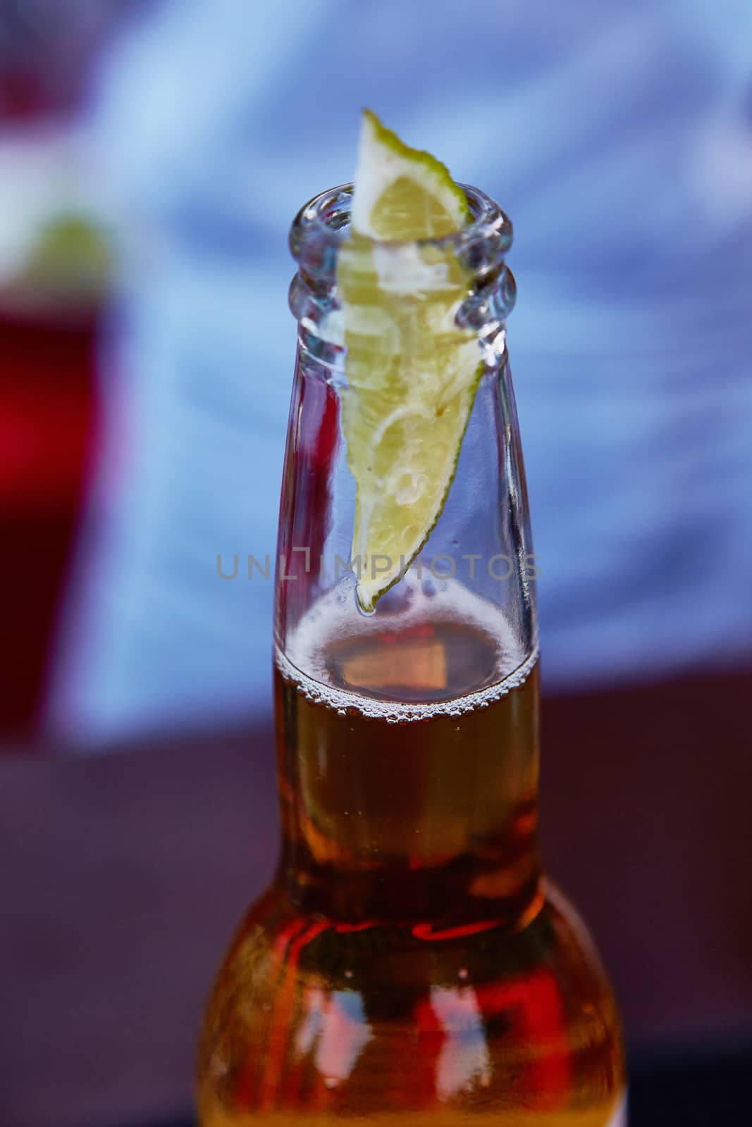 Beautiful ice cold beer in a bottle with a wedge of fresh lime