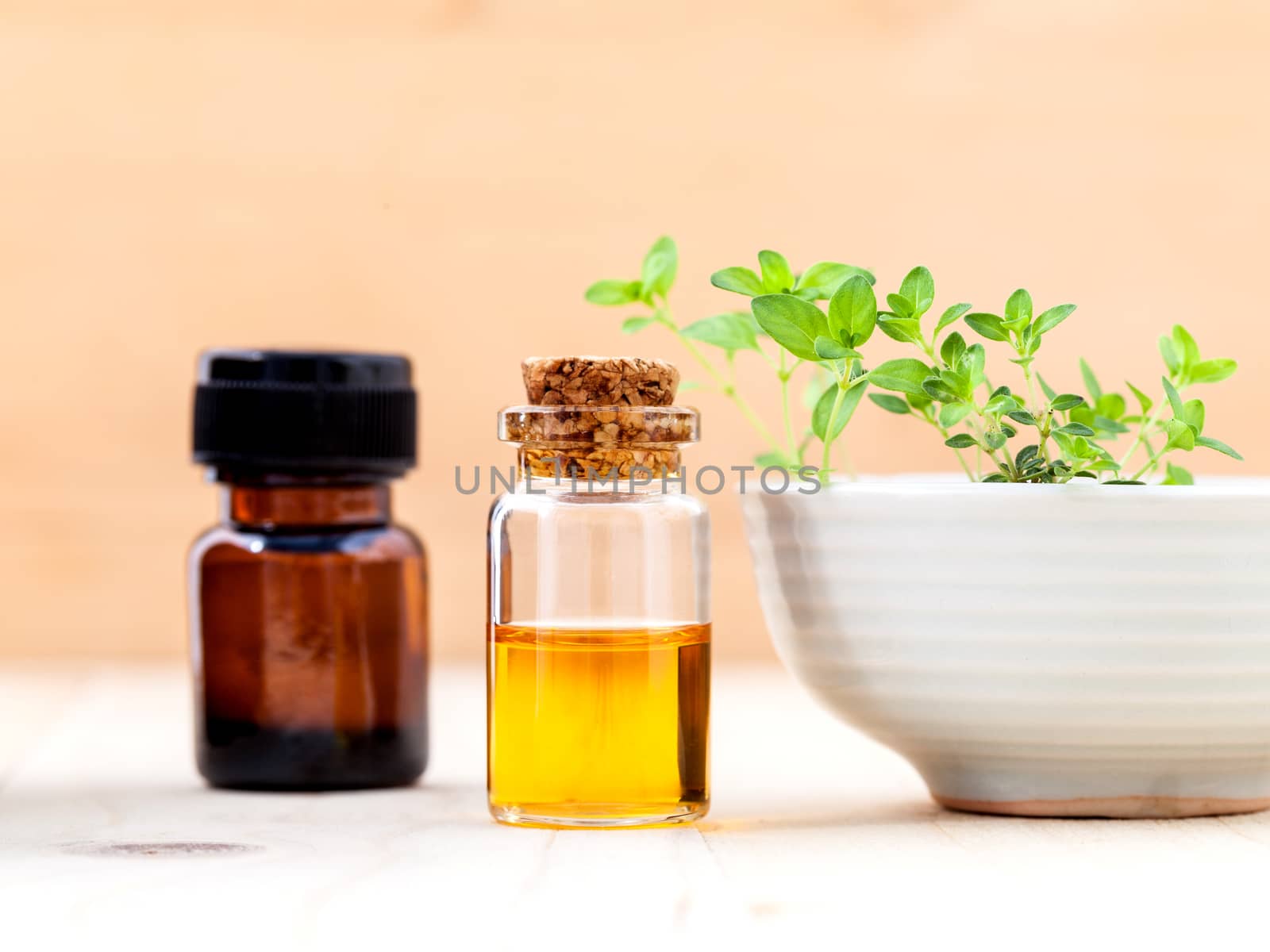 Bottle of essential oil and lemon thyme  leaf  on wooden background.