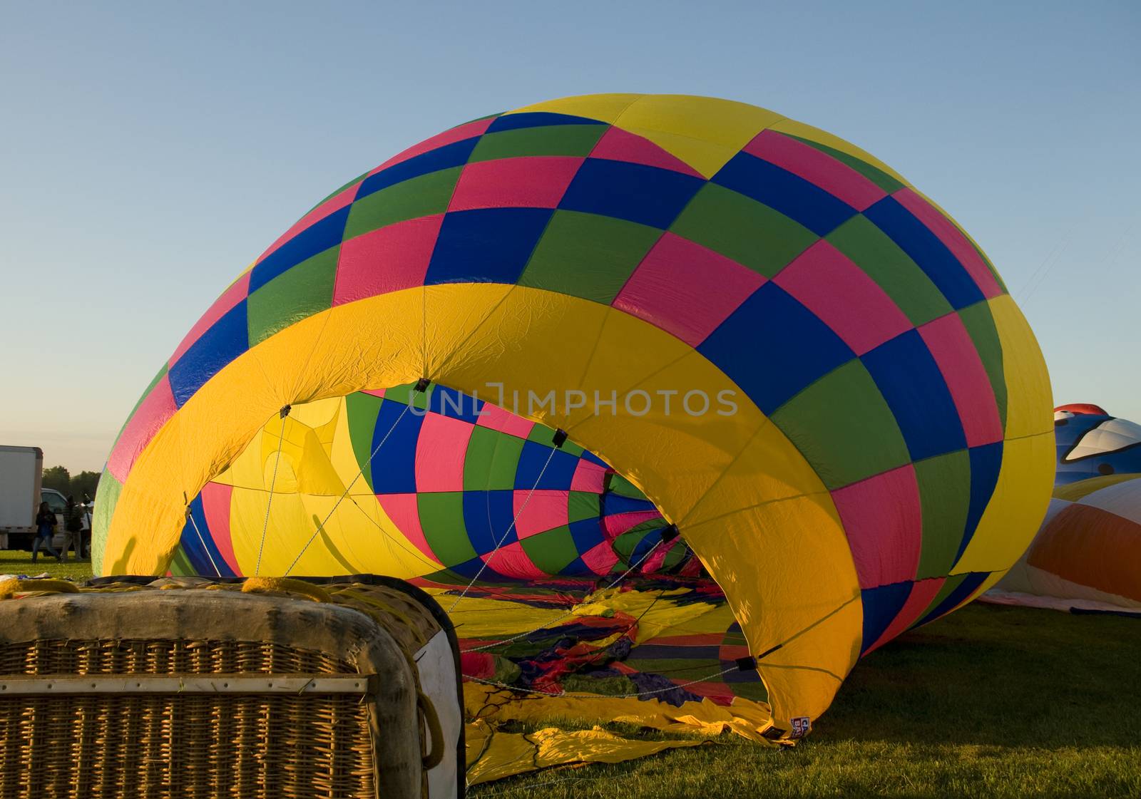 The colorful envelope of a hot-air balloon being inflated on the ground.