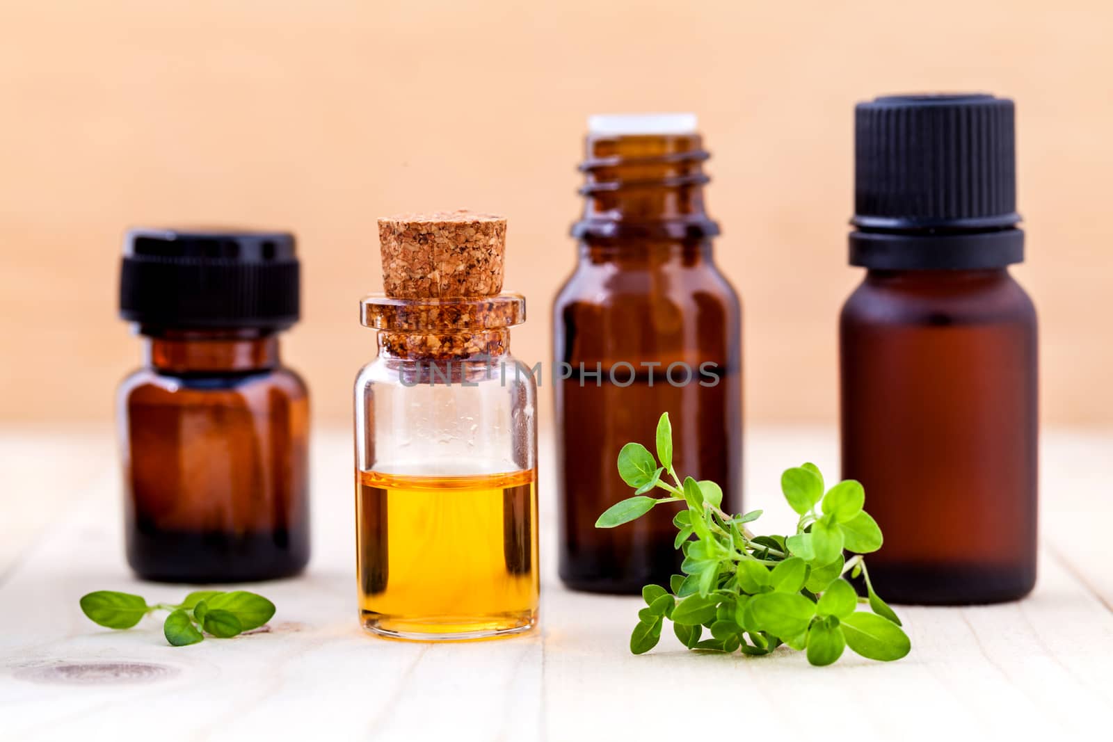 Bottle of essential oil and lemon thyme  leaf  on wooden background.