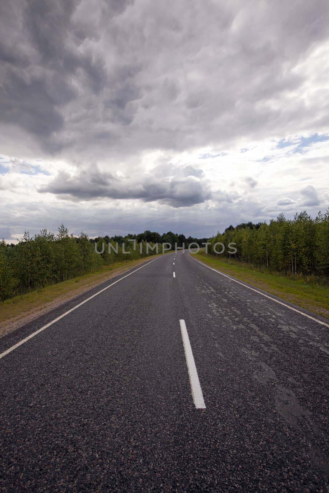   the small asphalted road to time of storm weather. Belarus