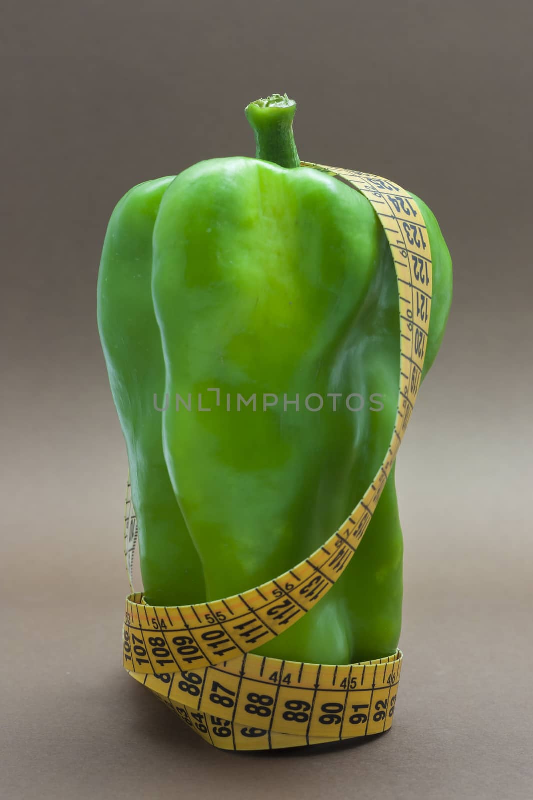 Green pepper isolated on a brown background to understand a concept to healthy eating